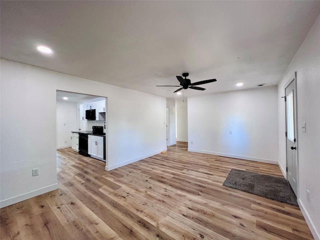 1402 E Marion St, Knoxville, IA 50138 - unfurnished living room featuring light wood-style flooring, baseboards, a ceiling fan, and recessed lighting