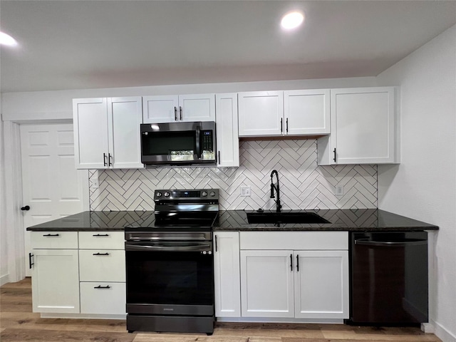 1402 E Marion St, Knoxville, IA 50138 - kitchen featuring white cabinets, stainless steel microwave, a sink, and range with electric stovetop