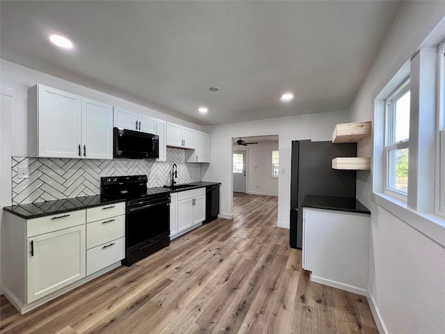 1402 E Marion St, Knoxville, IA 50138 - kitchen with a sink, black appliances, backsplash, and dark countertops