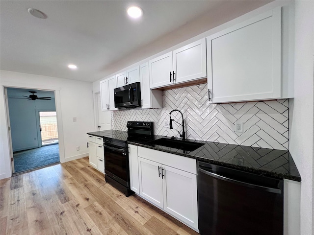 1402 E Marion St, Knoxville, IA 50138 - kitchen featuring a sink, tasteful backsplash, black appliances, and white cabinets
