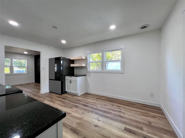 1402 E Marion St, Knoxville, IA 50138 - kitchen with light wood-style floors, freestanding refrigerator, visible vents, and a wealth of natural light