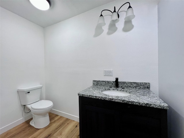1402 E Marion St, Knoxville, IA 50138 - half bath with vanity, baseboards, toilet, and wood finished floors