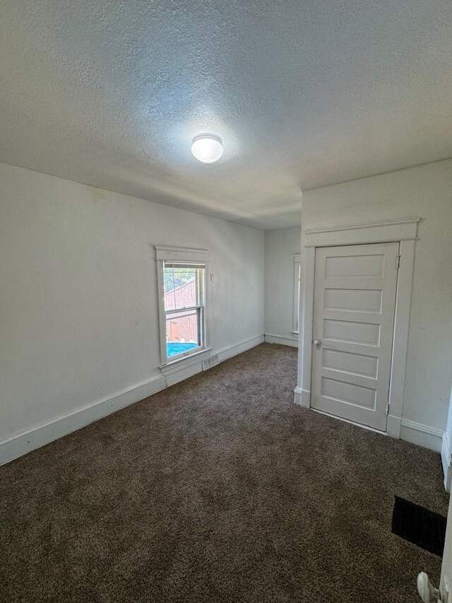 500 1st Ave W, Newton, IA 50208 - carpeted empty room with visible vents, baseboards, and a textured ceiling