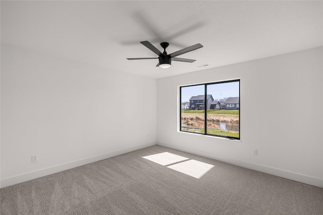empty room with visible vents, baseboards, ceiling fan, and light carpet