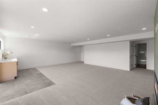 unfurnished living room featuring light carpet, baseboards, and recessed lighting