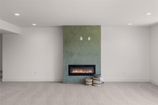 unfurnished living room featuring recessed lighting, carpet, a large fireplace, and baseboards