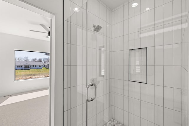 bathroom with a shower stall and ceiling fan