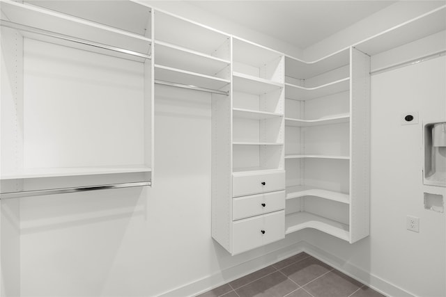 walk in closet featuring dark tile patterned floors