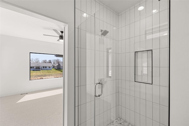 bathroom featuring ceiling fan and a stall shower
