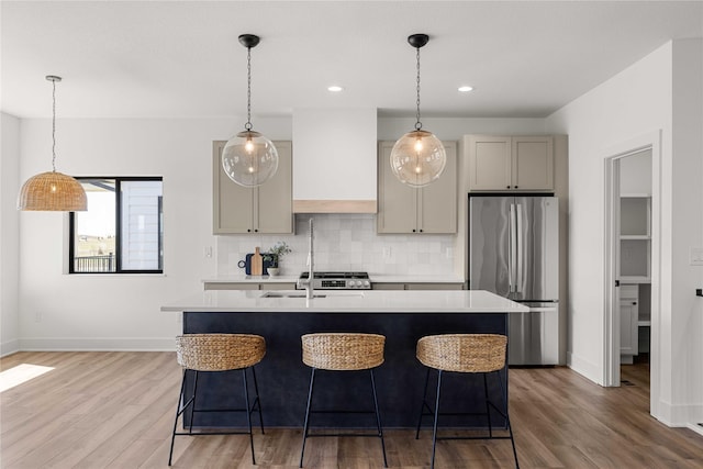 kitchen with tasteful backsplash, premium range hood, freestanding refrigerator, and light countertops