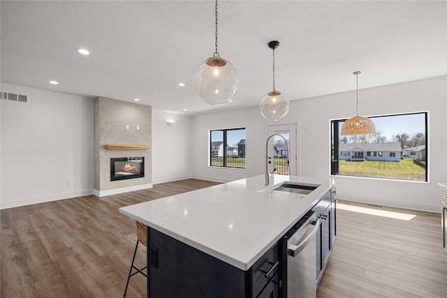 kitchen with light wood-style floors, visible vents, recessed lighting, a sink, and hanging light fixtures