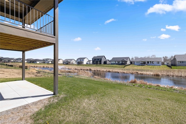 view of yard featuring a water view, a patio, and a residential view