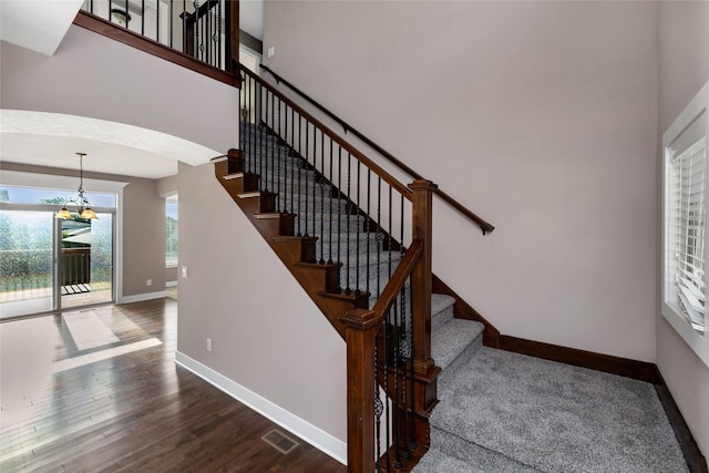 3555 NW 164th St, Clive, IA 50325 - stairway featuring a chandelier, wood finished floors, and arched walkways
