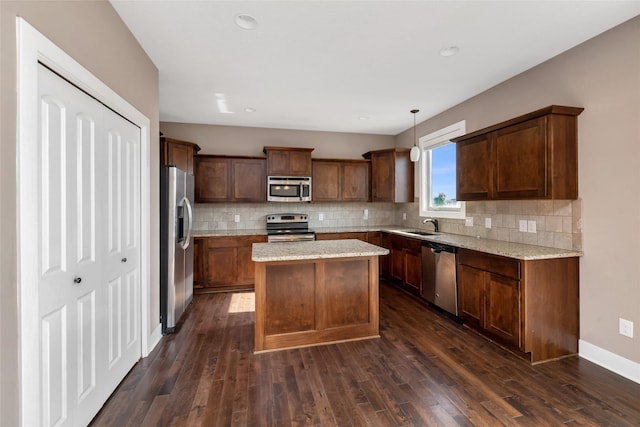 3555 NW 164th St, Clive, IA 50325 - kitchen featuring appliances with stainless steel finishes, backsplash, a kitchen island, dark wood finished floors, and recessed lighting