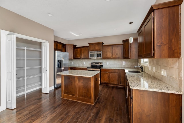 3555 NW 164th St, Clive, IA 50325 - kitchen featuring stainless steel appliances, dark wood finished floors, a kitchen island, light stone countertops, and backsplash