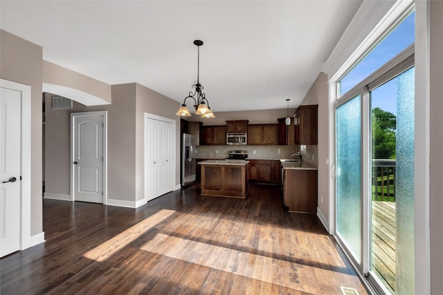 3555 NW 164th St, Clive, IA 50325 - kitchen with appliances with stainless steel finishes, a center island, light countertops, dark wood-type flooring, and a chandelier