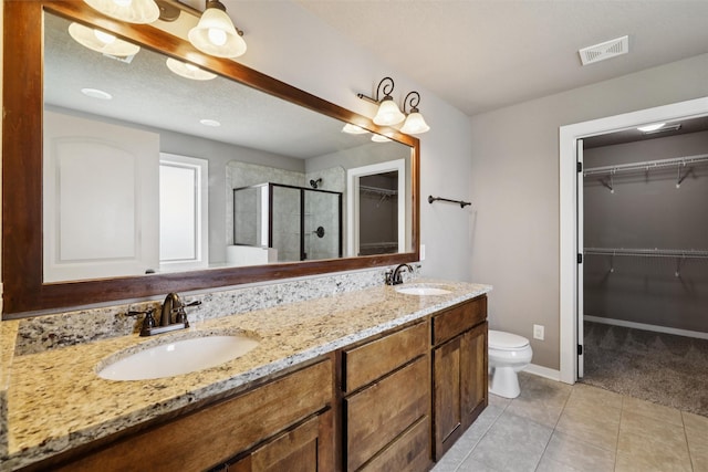 3555 NW 164th St, Clive, IA 50325 - bathroom with a shower stall, a walk in closet, double vanity, and tile patterned floors