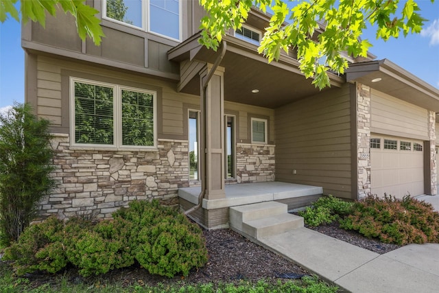 3555 NW 164th St, Clive, IA 50325 - entrance to property featuring stone siding, covered porch, and a garage
