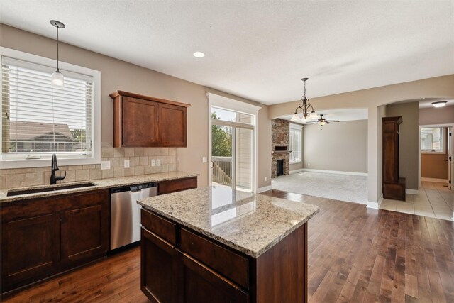 3555 NW 164th St, Clive, IA 50325 - kitchen with dishwasher, dark wood-style floors, a fireplace, decorative backsplash, and open floor plan