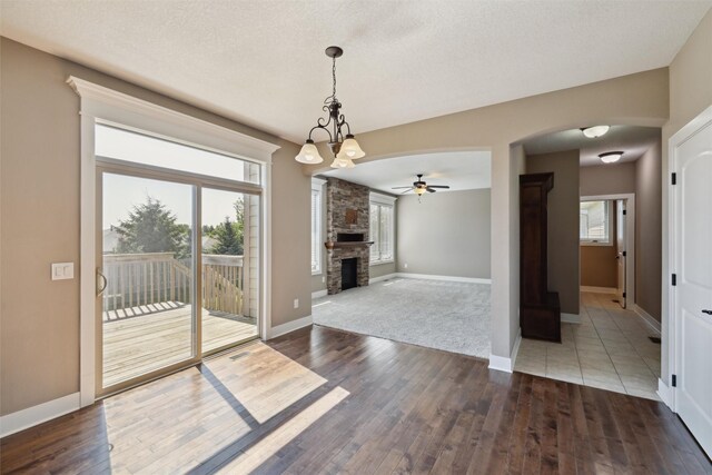 3555 NW 164th St, Clive, IA 50325 - unfurnished dining area featuring a ceiling fan, arched walkways, wood-type flooring, and a fireplace