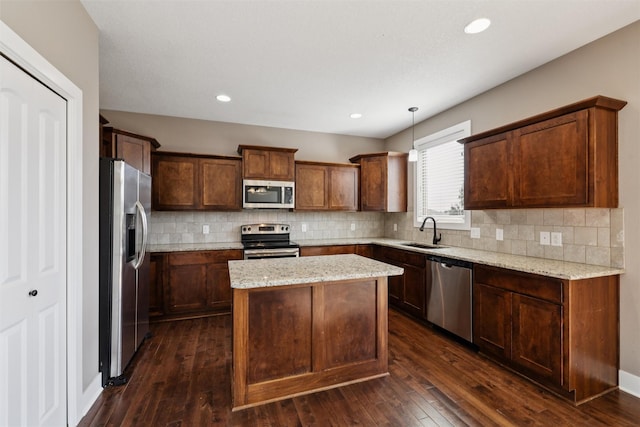 3555 NW 164th St, Clive, IA 50325 - kitchen with stainless steel appliances, a kitchen island, backsplash, dark wood-type flooring, and light stone counters