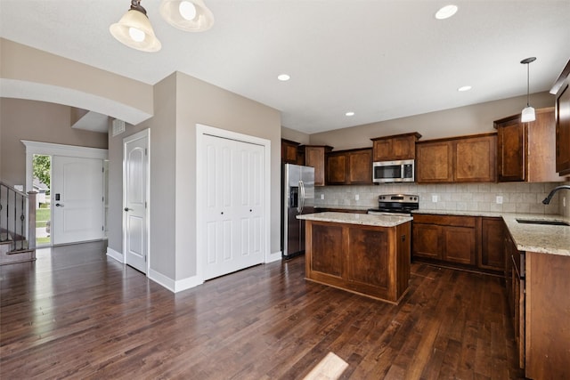 3555 NW 164th St, Clive, IA 50325 - kitchen featuring appliances with stainless steel finishes, dark wood-type flooring, tasteful backsplash, light stone countertops, and recessed lighting