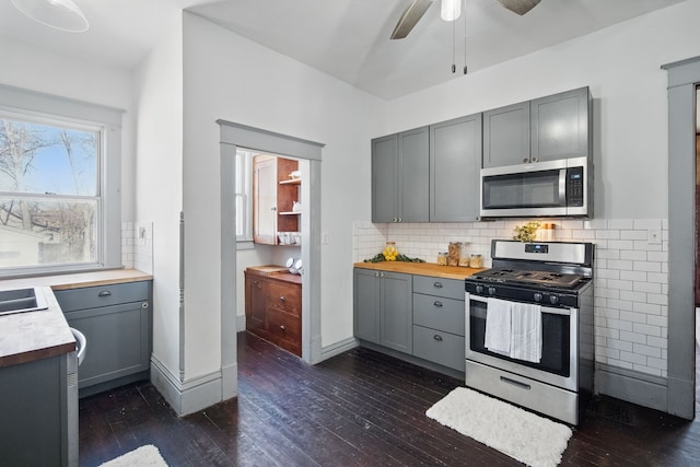 404 W Boston Ave, Indianola, IA 50125 - kitchen featuring appliances with stainless steel finishes, gray cabinetry, dark wood-style flooring, a ceiling fan, and backsplash