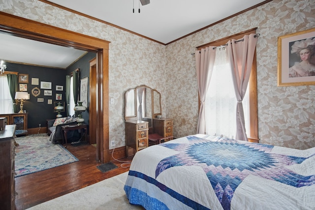 404 W Boston Ave, Indianola, IA 50125 - bedroom with wood finished floors, multiple windows, ornamental molding, wallpapered walls, and a ceiling fan