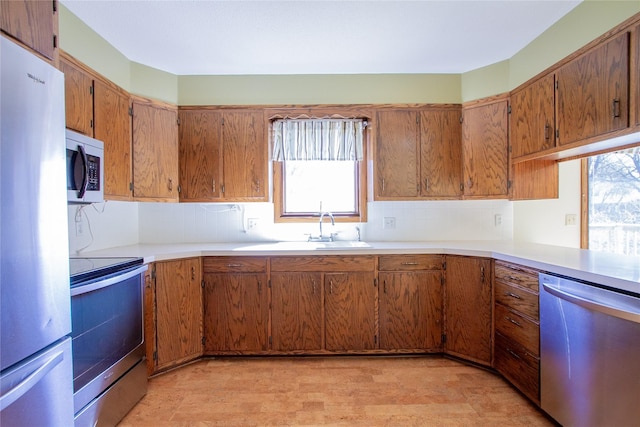 1412 Country Club Dr, Pella, IA 50219 - kitchen featuring stainless steel appliances, a sink, healthy amount of natural light, and light countertops