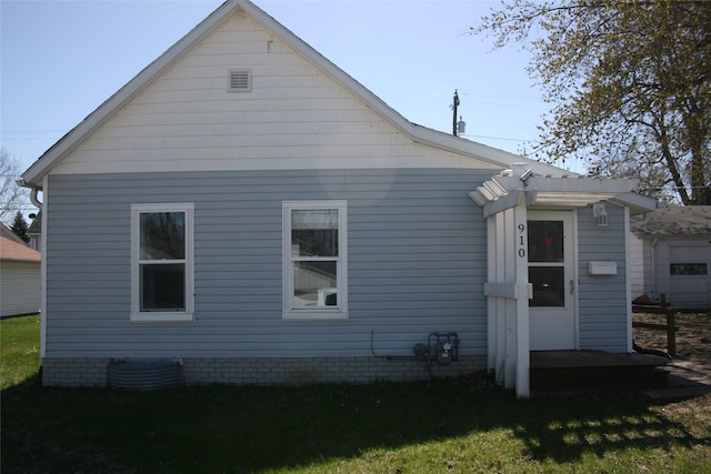 back of property with a pergola and a lawn