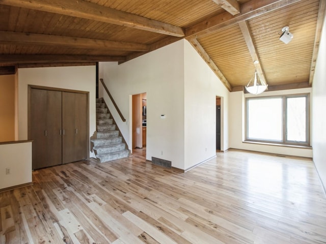 unfurnished living room with stairway, vaulted ceiling with beams, light wood-style flooring, wooden ceiling, and visible vents