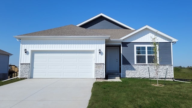 1360 Northview Dr, Waukee, IA 50263 - ranch-style home with stone siding, a front lawn, driveway, a garage, and roof with shingles