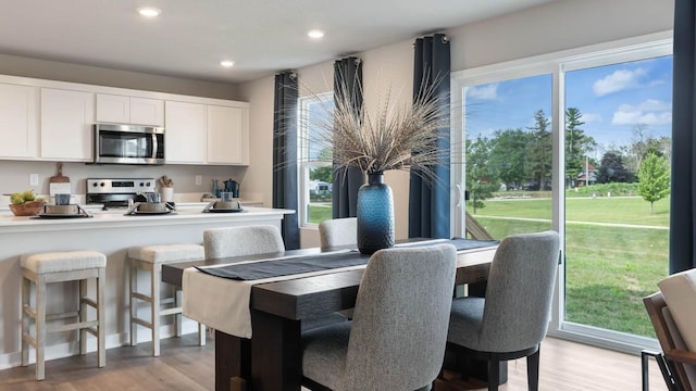dining area featuring light wood finished floors and recessed lighting