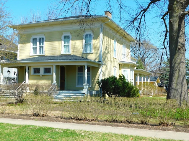 italianate home featuring a porch and a chimney