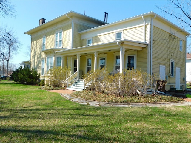 italianate home featuring a porch, a chimney, and a front lawn