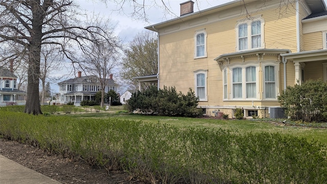 view of home's exterior featuring central AC and a chimney