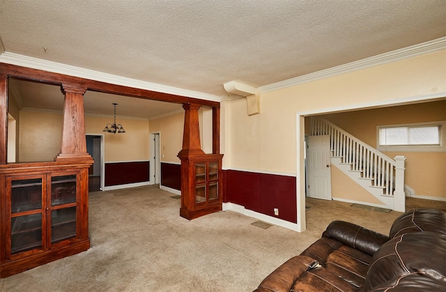 1632 Mamie Eisenhower Ave, Boone, IA 50036 - carpeted living room with stairway, crown molding, decorative columns, and a textured ceiling
