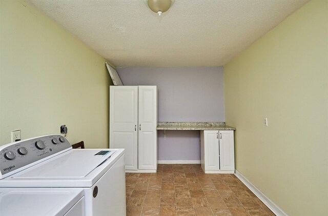 1632 Mamie Eisenhower Ave, Boone, IA 50036 - washroom with cabinet space, washing machine and clothes dryer, a textured ceiling, stone finish floors, and baseboards