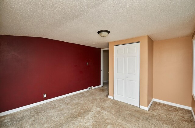 1632 Mamie Eisenhower Ave, Boone, IA 50036 - unfurnished bedroom featuring carpet flooring, a closet, baseboards, and a textured ceiling