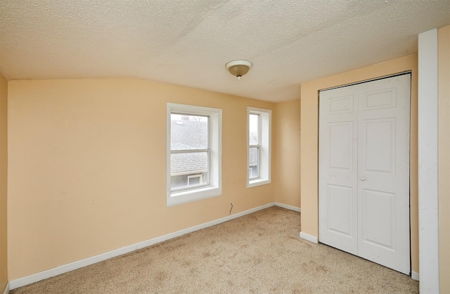 1632 Mamie Eisenhower Ave, Boone, IA 50036 - unfurnished bedroom with carpet flooring, a closet, baseboards, and a textured ceiling