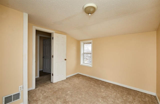 1632 Mamie Eisenhower Ave, Boone, IA 50036 - carpeted empty room with a textured ceiling, vaulted ceiling, and baseboards