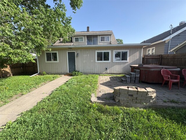 1632 Mamie Eisenhower Ave, Boone, IA 50036 - back of property featuring a hot tub, a patio, a chimney, and a fire pit