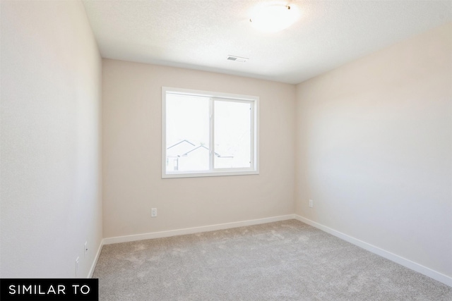 carpeted empty room featuring visible vents, baseboards, and a textured ceiling