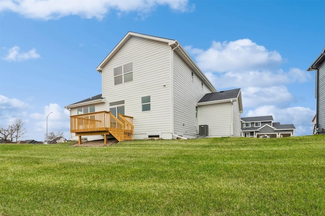 back of property with central AC, a deck, and a lawn