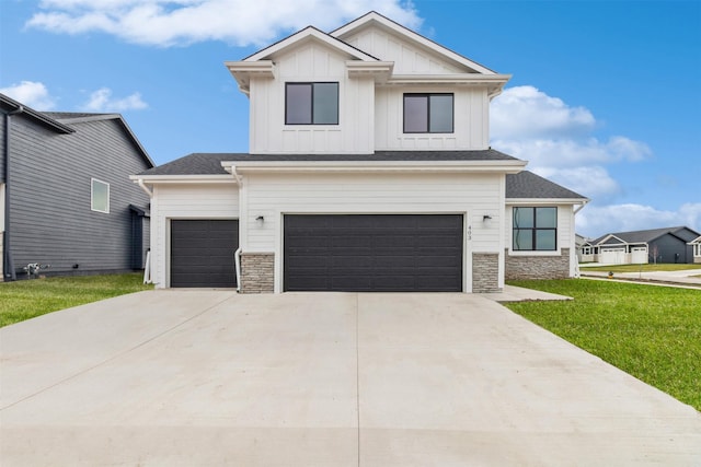 modern farmhouse style home featuring concrete driveway, a front yard, stone siding, and a garage