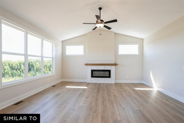 unfurnished living room with light wood-style flooring, a ceiling fan, a glass covered fireplace, visible vents, and baseboards