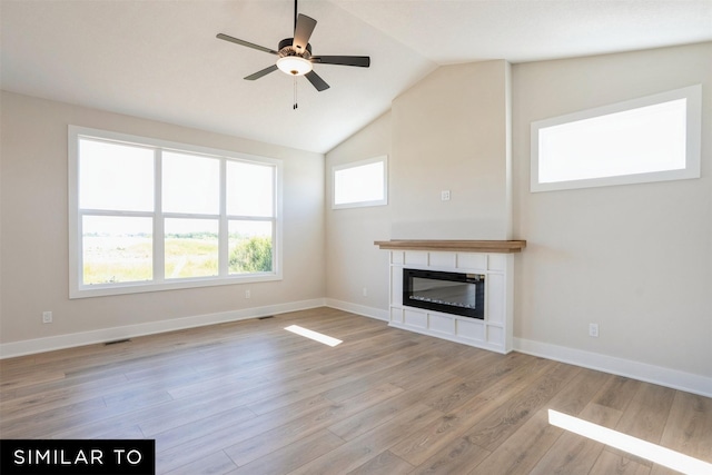 unfurnished living room with visible vents, baseboards, light wood-type flooring, a ceiling fan, and a glass covered fireplace