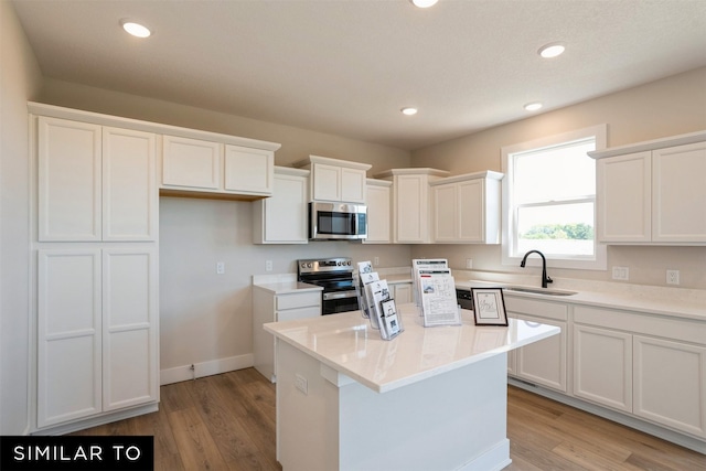 kitchen featuring light wood-style floors, appliances with stainless steel finishes, and white cabinetry