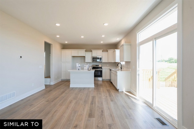 kitchen featuring a sink, visible vents, light wood-style flooring, and appliances with stainless steel finishes