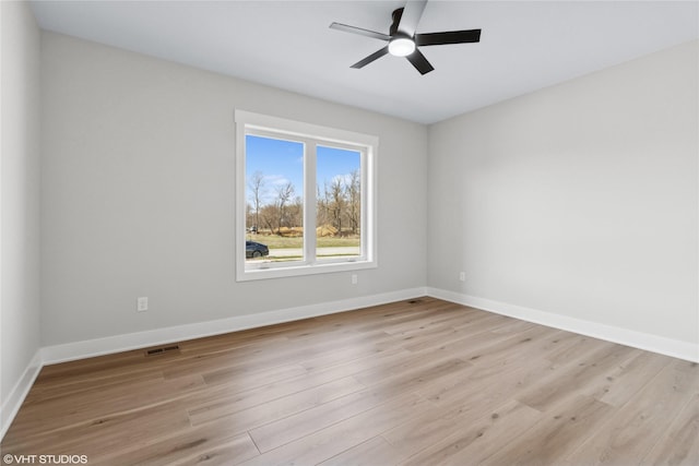 unfurnished room with visible vents, ceiling fan, light wood finished floors, and baseboards